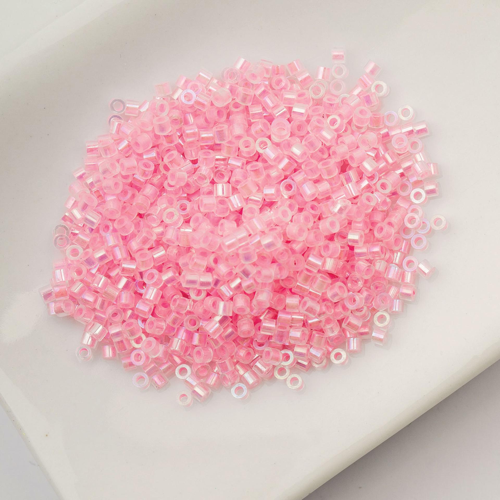 John Bead Cylin 11/0 Glow in the Dark Cylindrical Seed Beads - Pink AB, 25g sitting in dish