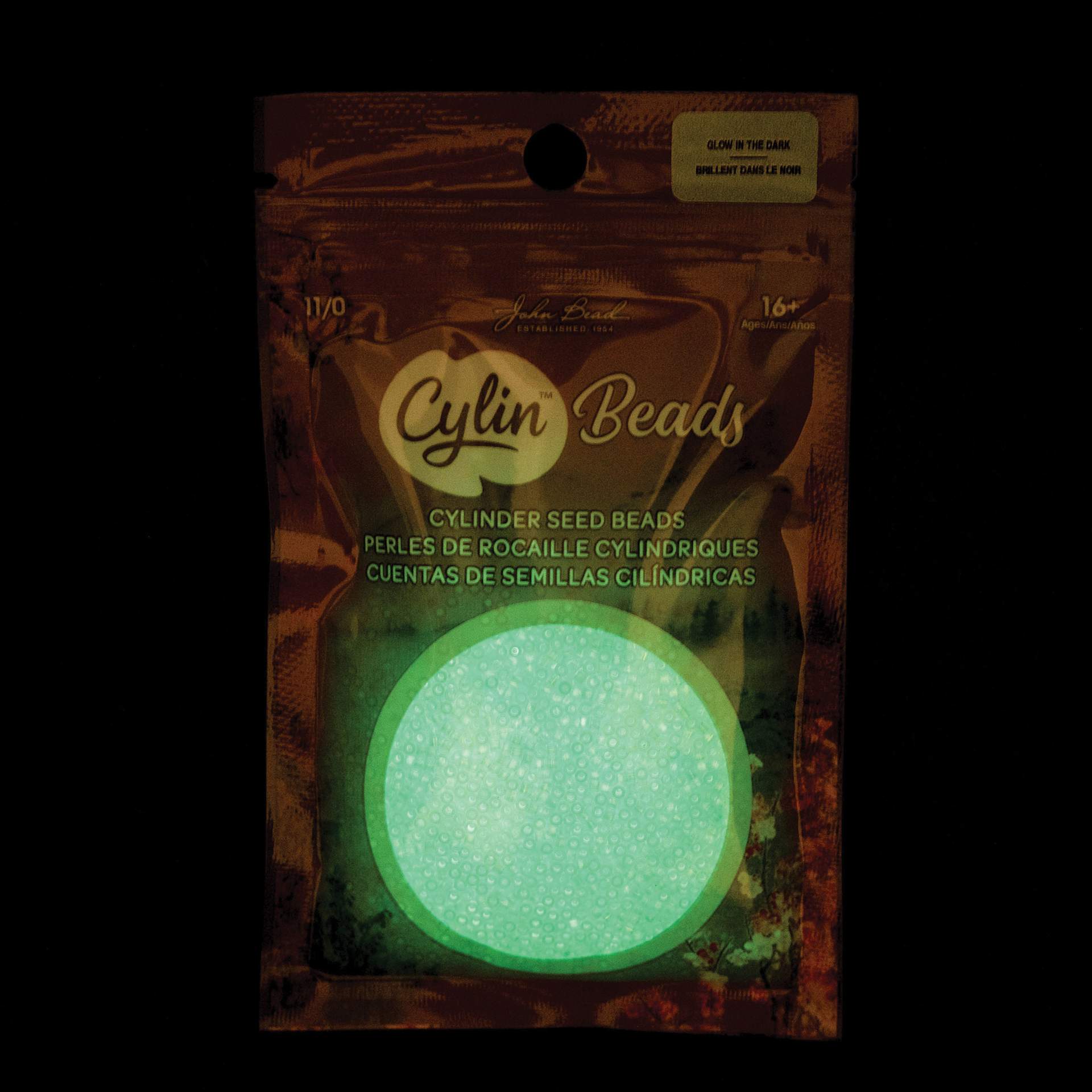 John Bead Cylin 11/0 Glow in the Dark Cylindrical Seed Beads - Blue AB, 25g front of packaging to show glow effect