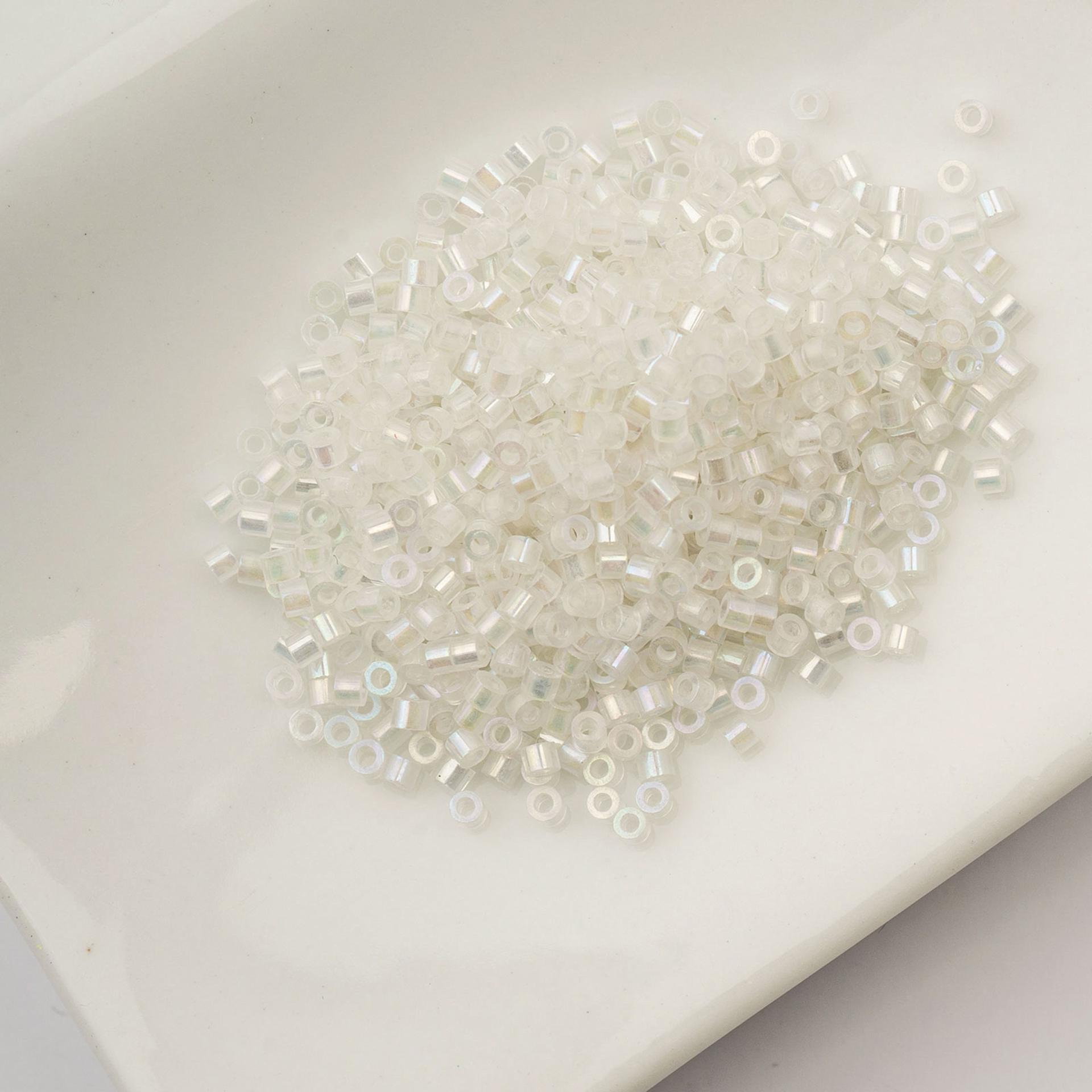 John Bead Cylin 11/0 Glow in the Dark Cylindrical Seed Beads - White to Turquoise AB, 25g sitting in dish