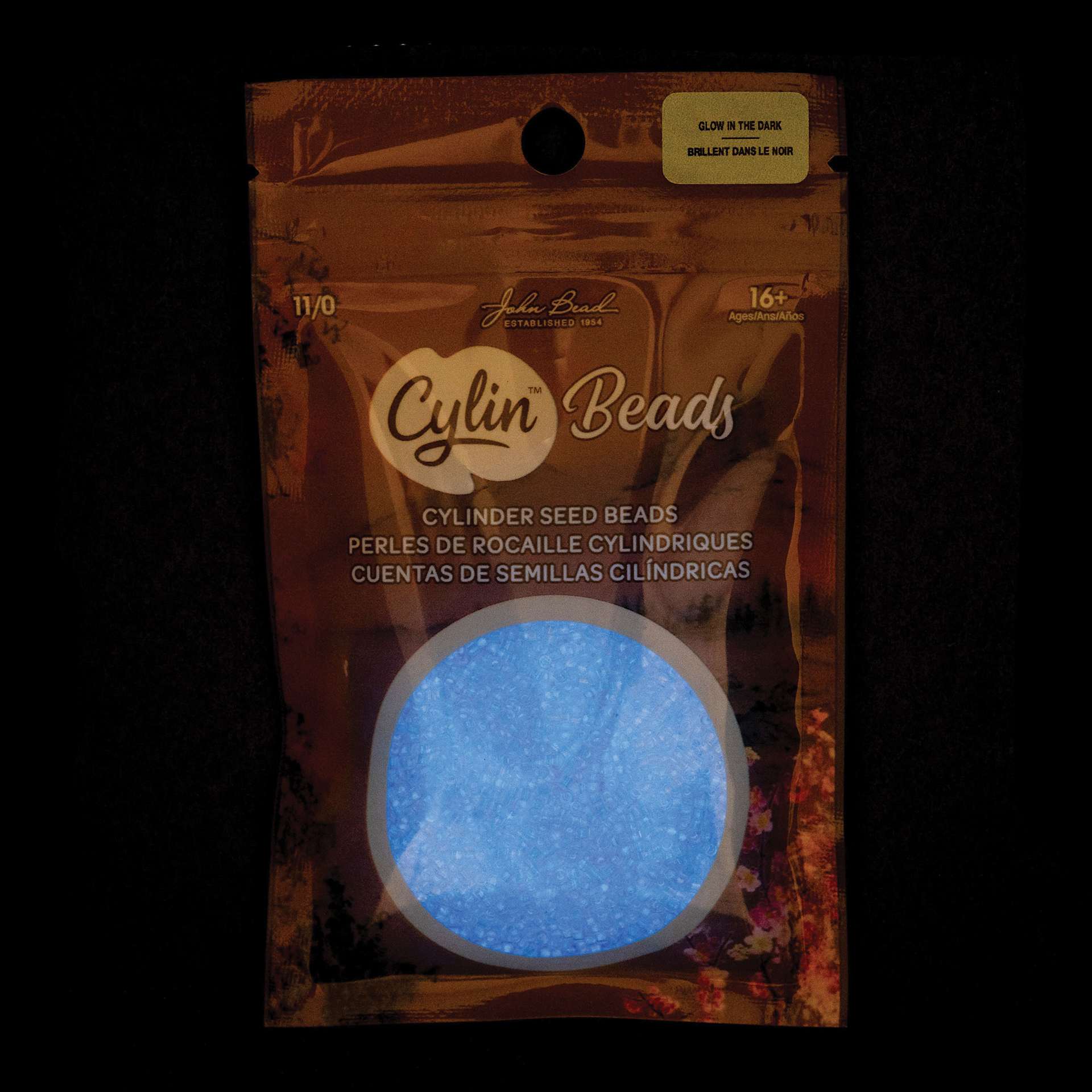 John Bead Cylin 11/0 Glow in the Dark Cylindrical Seed Beads - Sky, 25g front of packaging to show glow effect