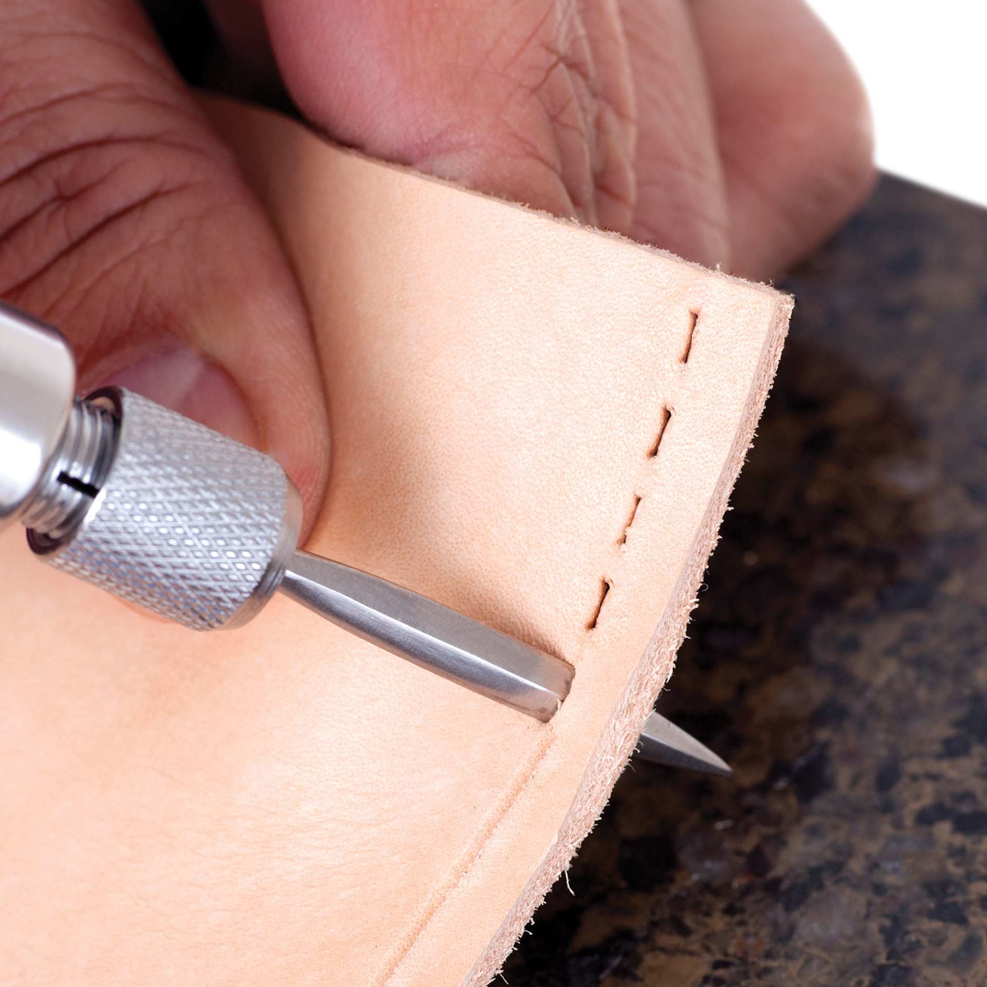 John Bead Metal Complex 4-in-1 Interchangeable Awl being used on leather