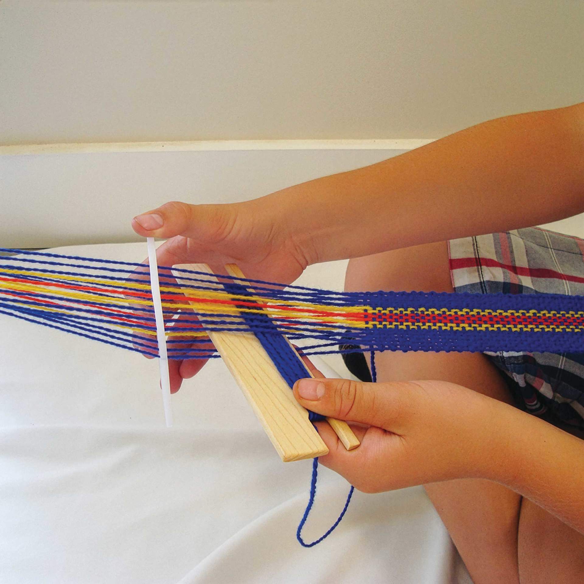 Friendly Loom Backstrap Loom Kit being used to weave included wool warp