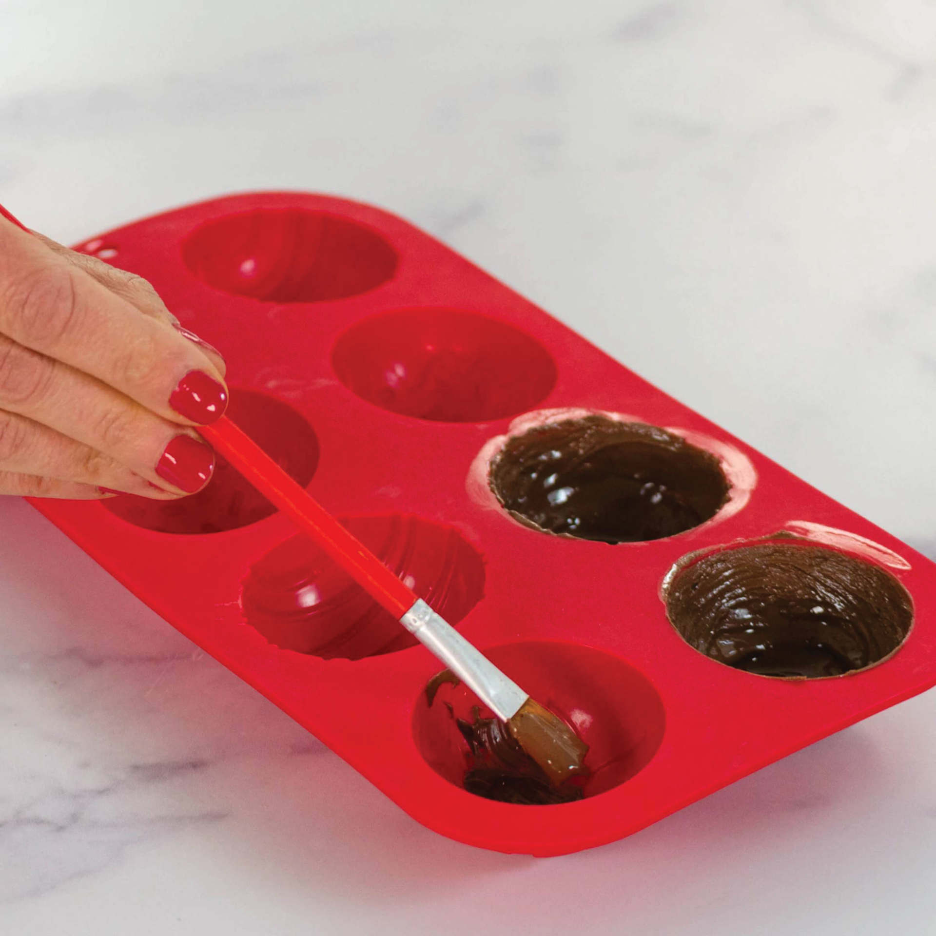 Handstand Kitchen I Heart Cocoa Bombs Silicone Mold (Applying melted chocolate inside mold)