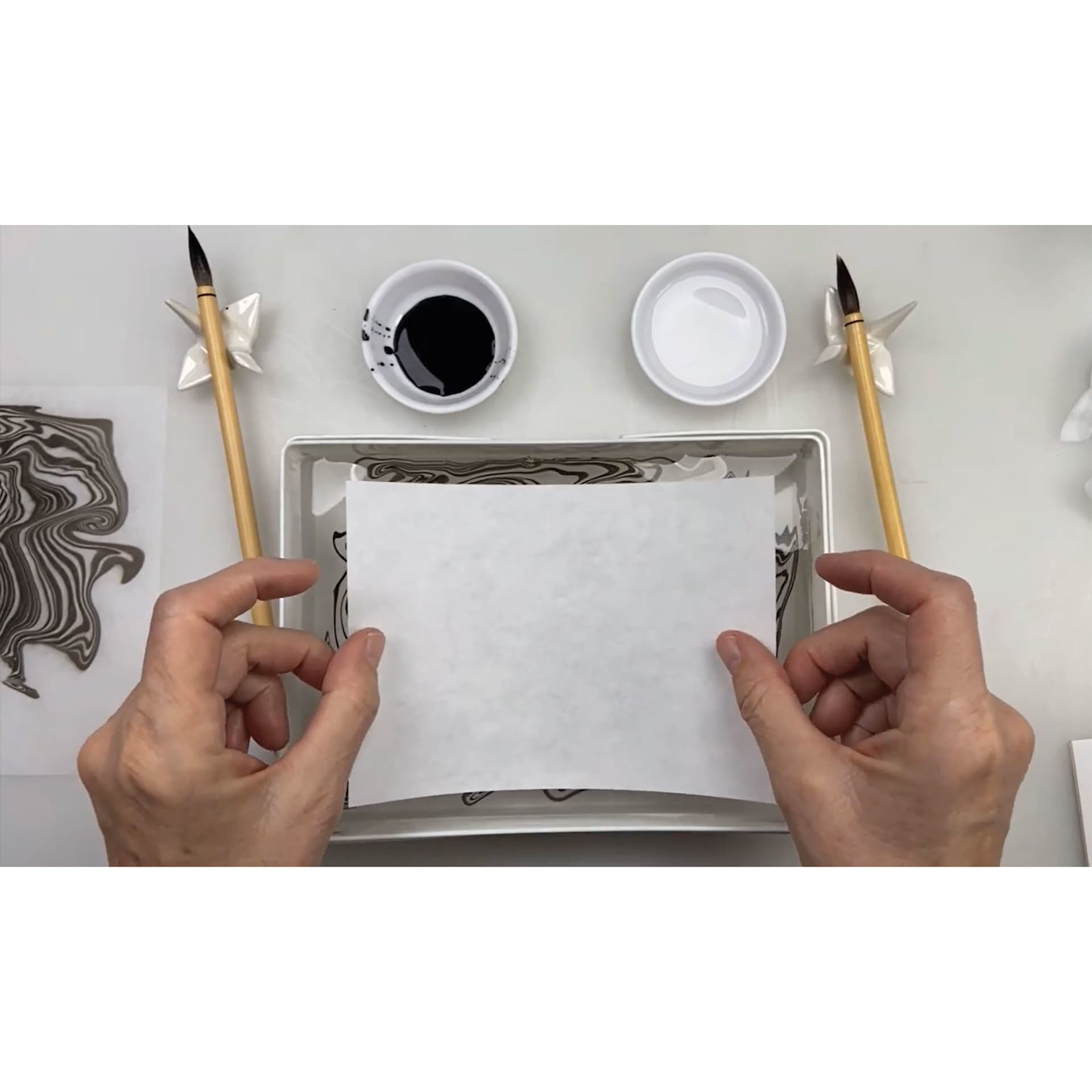 Yasutomo Suminagashi Kit, placing paper in suminagashi waterbath
