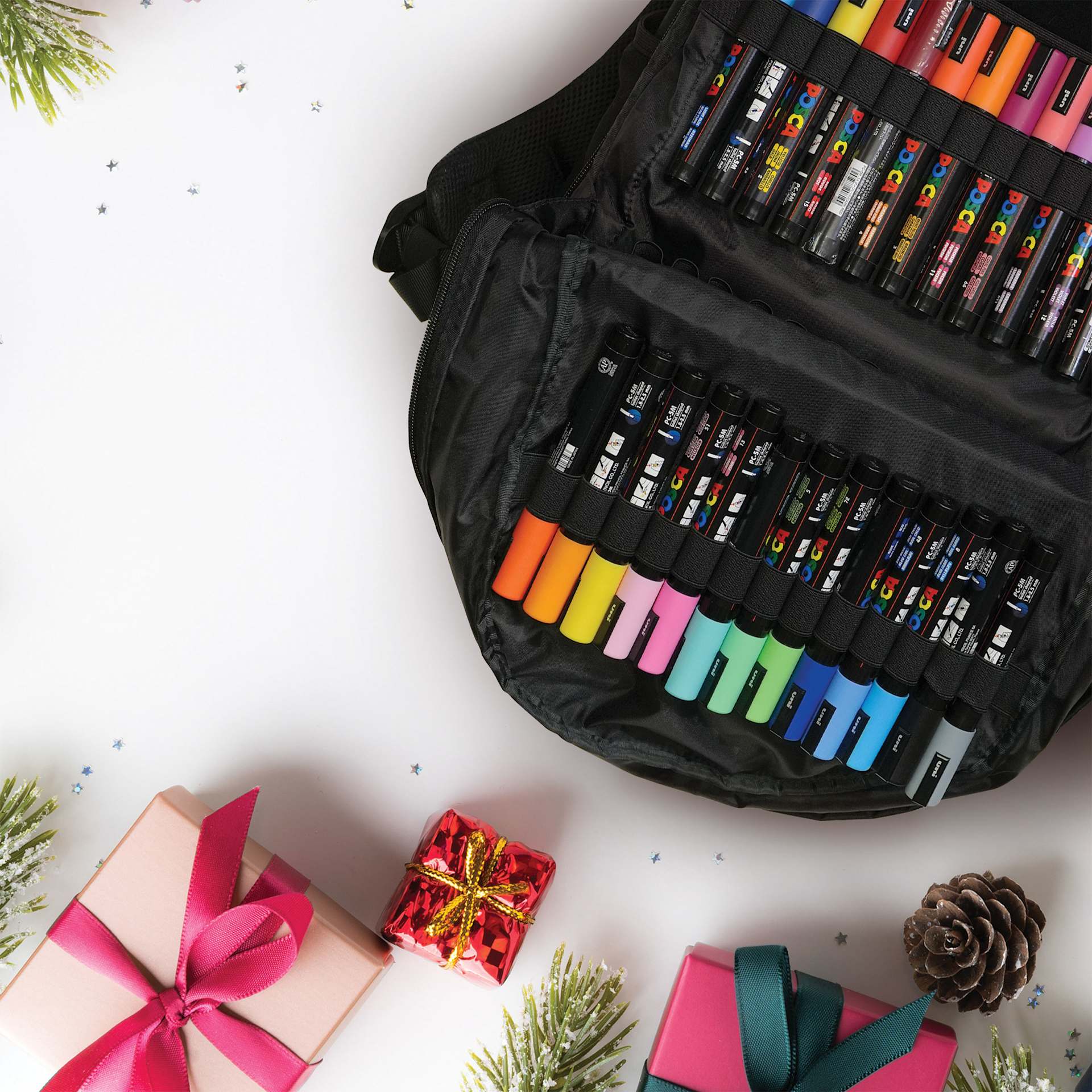Posca Artist Marker & Pencil Backpack Bundle, open backpack on table with gift boxes (not included)