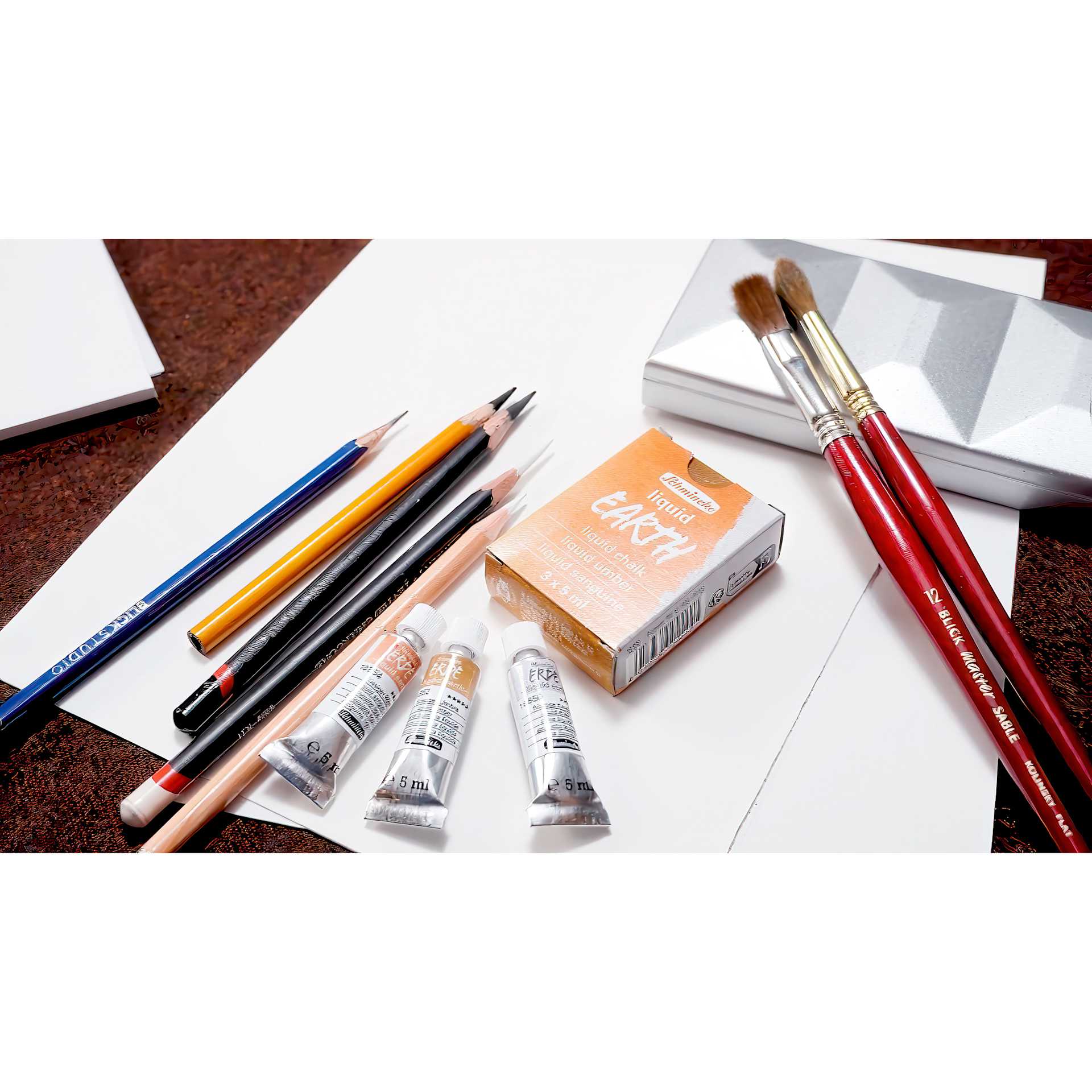 Schmincke Liquid Earth Watercolor, tubes on desk with other supplies (not included)