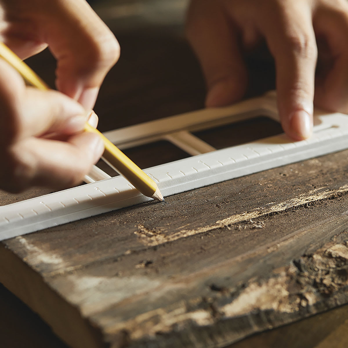 Fiskars Precision Hand Saw - Closeup of Crafter marking Barn wood for cutting
