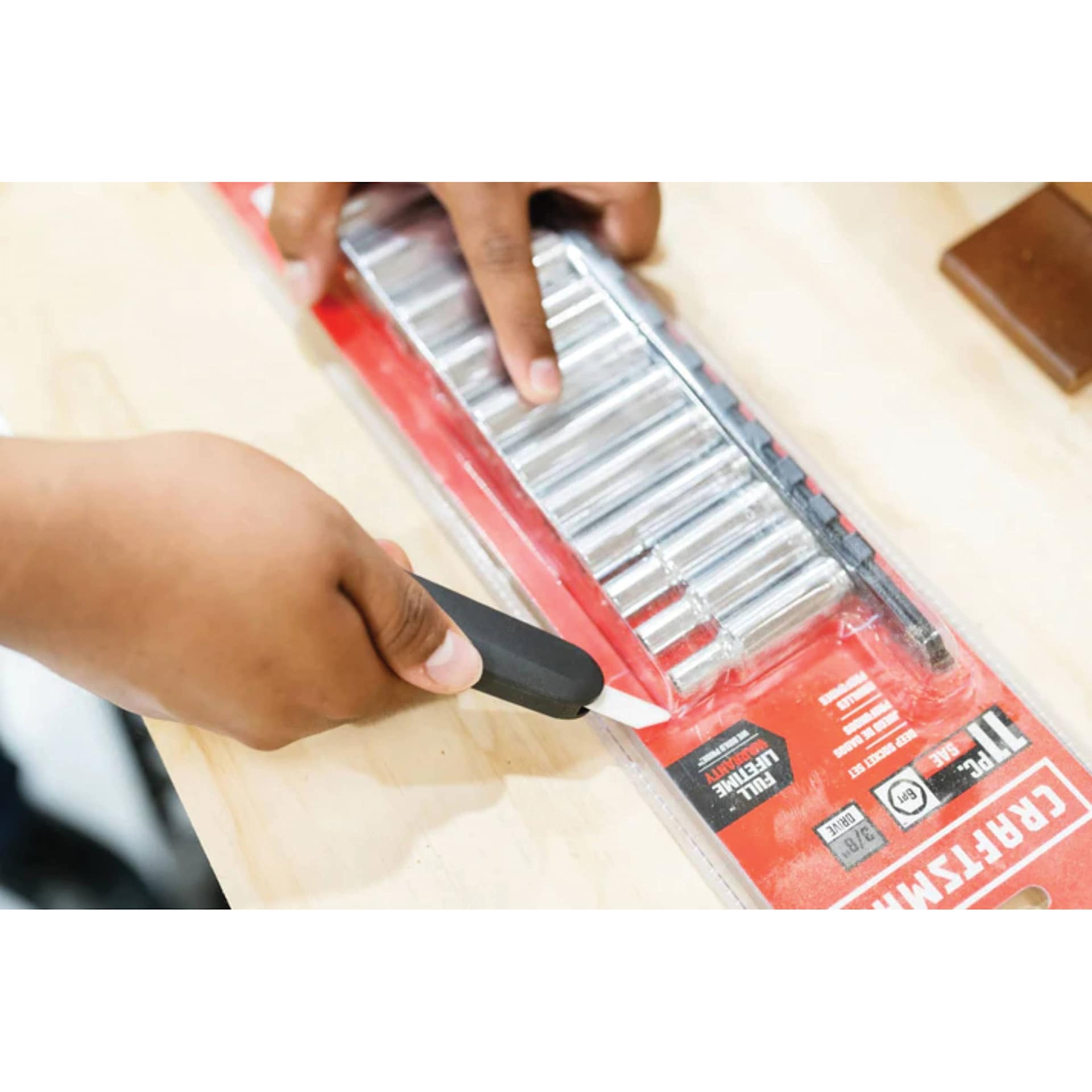 Slice Auto-Retractable Squeeze-Trigger Utility Knife, hand using the knife to open a package 