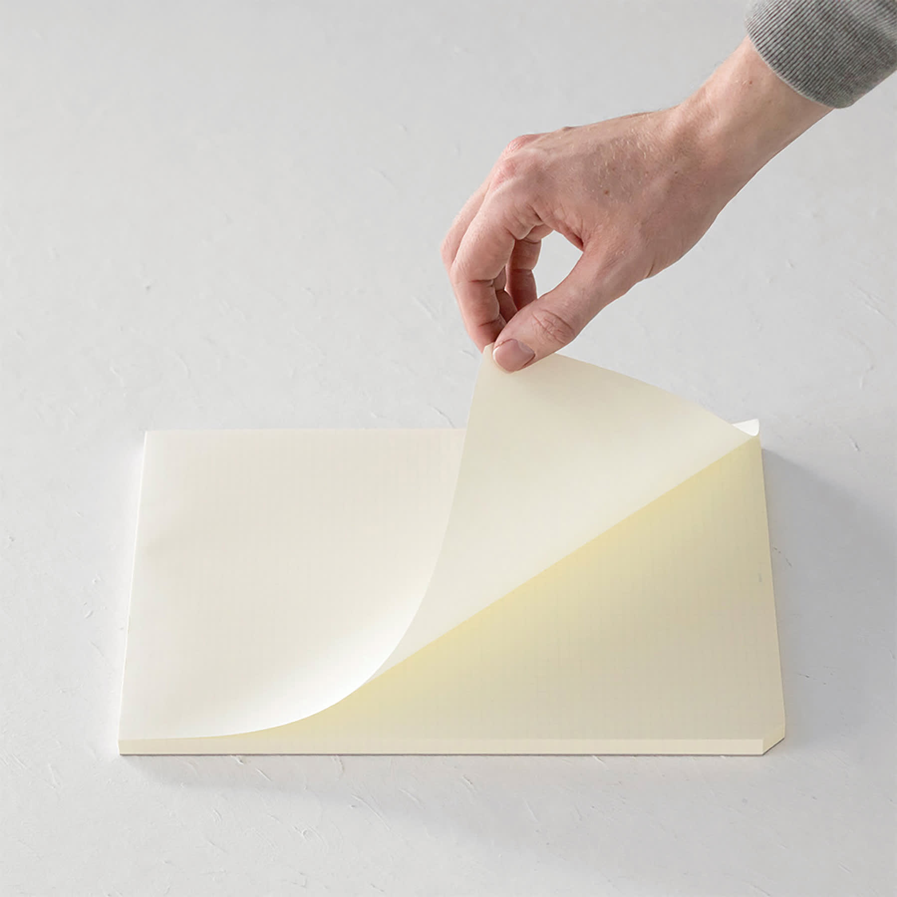 Midori MD Paper Pad - A4, Grid, White, 90 Sheets, sheet being lifted