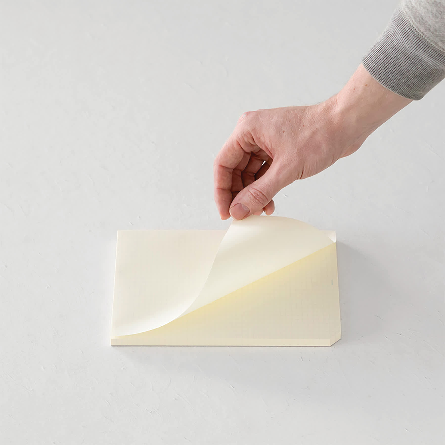 Midori MD Paper Pad - A5, Grid, White, 90 Sheets, sheet being lifted
