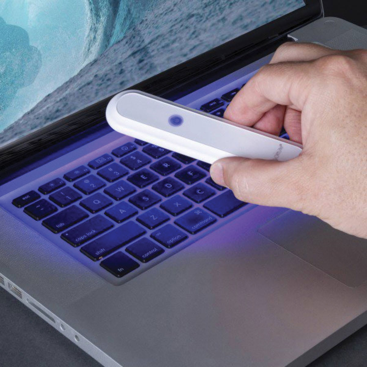 OttLite Compact Travel UVC Disinfecting Wand (Person disinfecting laptop)