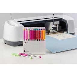 Cricut Pen Set - Two Extra Fine point pens shown with packaging and a Cricut machine