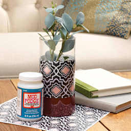 Jar of Mod Podge next to decorated plant pot sealed with Super Gloss Finish
