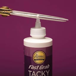 Aleene's Fast Grab Tacky Glue - 8 oz showing glue tip being trimmed off