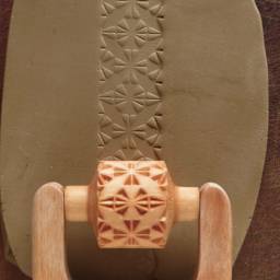MKM Pottery Tools Medium Handle Roller - 4 Leaf Quilt Block being applied to clay