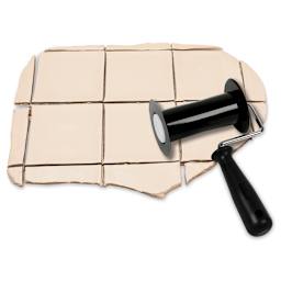 Amaco Clay Tile Cutter - Cutter laying on square-cut slab of clay
