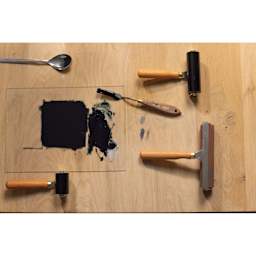 Pebeo Lino Inking Brayer - 5 cm beside ink covered glass plate and other printmaking tools