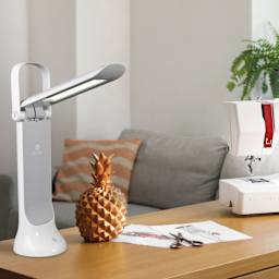 OttLite Dimmable LED Task Lamp - White, on a sewing desk