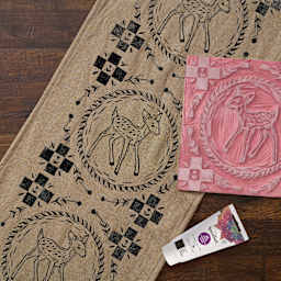 Speedball Speedy Carve Block, carved with fawn design next to block printed fabric and ink