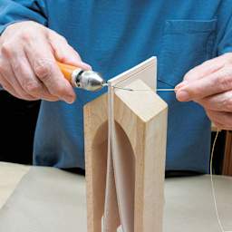 Speedy Stitcher Sewing Awl Kit, in use, punching thread through leather
