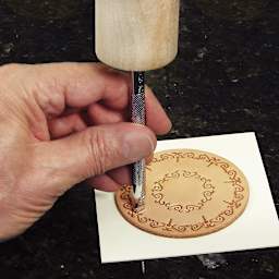 Realeather Leather Tooling Sets - Hand holding tool decorating small leather circle
