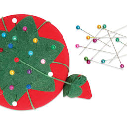 Dritz Tomato Pin Cushion - 2-3/4" next to laid out pearlized pins (not included)