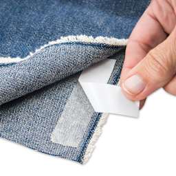Singer Hemming Kit, hand peeling tape revealing adhesive