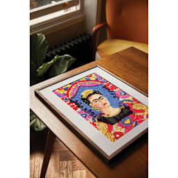 DMC The Masters Collection Cross Stitch Kit - “The Frame” by Frida Kahlo, Musée National d'Art Moderne in a wooden frame.