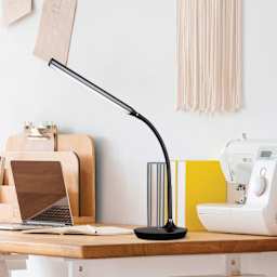 OttLite Extended Reach LED Desk Lamp - Black, on a craft table