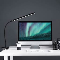 OttLite Clip-On LED Easel Lamp - Black, on a desk with a computer