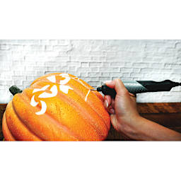 Dremel General Purpose Accessory Kit - Person using tool to carve pumpkin
