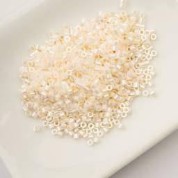 John Bead Cylin 11/0 Ceylon Cylindrical Seed Beads - Opaque White Bisque, 25g sitting in dish