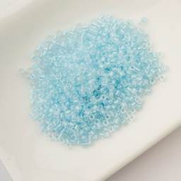 John Bead Cylin 11/0 Glow in the Dark Cylindrical Seed Beads - Sky, 25g sitting in dish