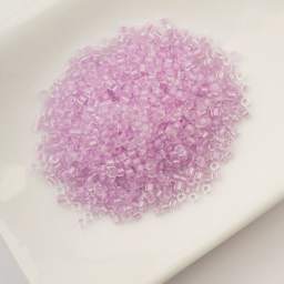 John Bead Cylin 11/0 Glow in the Dark Cylindrical Seed Beads - Violet, 25g sitting in dish