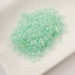 John Bead Cylin 11/0 Glow in the Dark Cylindrical Seed Beads - Green AB, 25g sitting in dish