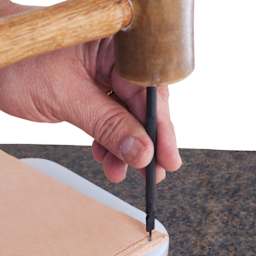 John Bead Metal Complex Leather Lacing Chisel - 1-Prong, Straight, 3.1 mm being used on leather with mallet