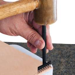 John Bead Metal Complex Leather Lacing Chisel - 8-Prong, Straight, 3.1 mm being used on leather with mallet