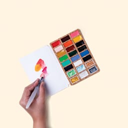 Person using the Viviva Watercolor Paint Pan Deluxe Set.