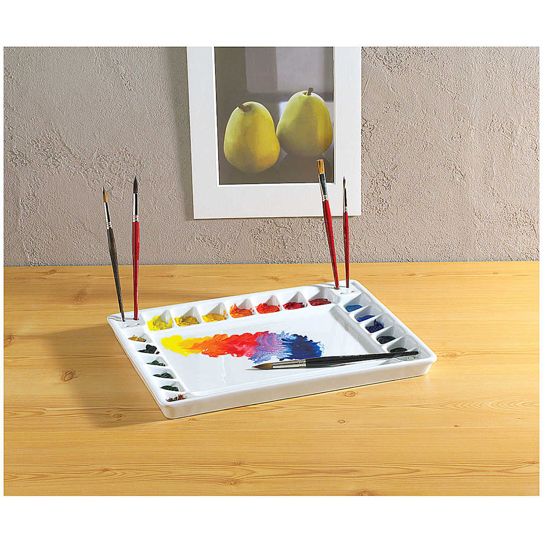 Open in modal - Tom Lynch Porcelain Palette shown on table with wells filled with paint, and brushes stored