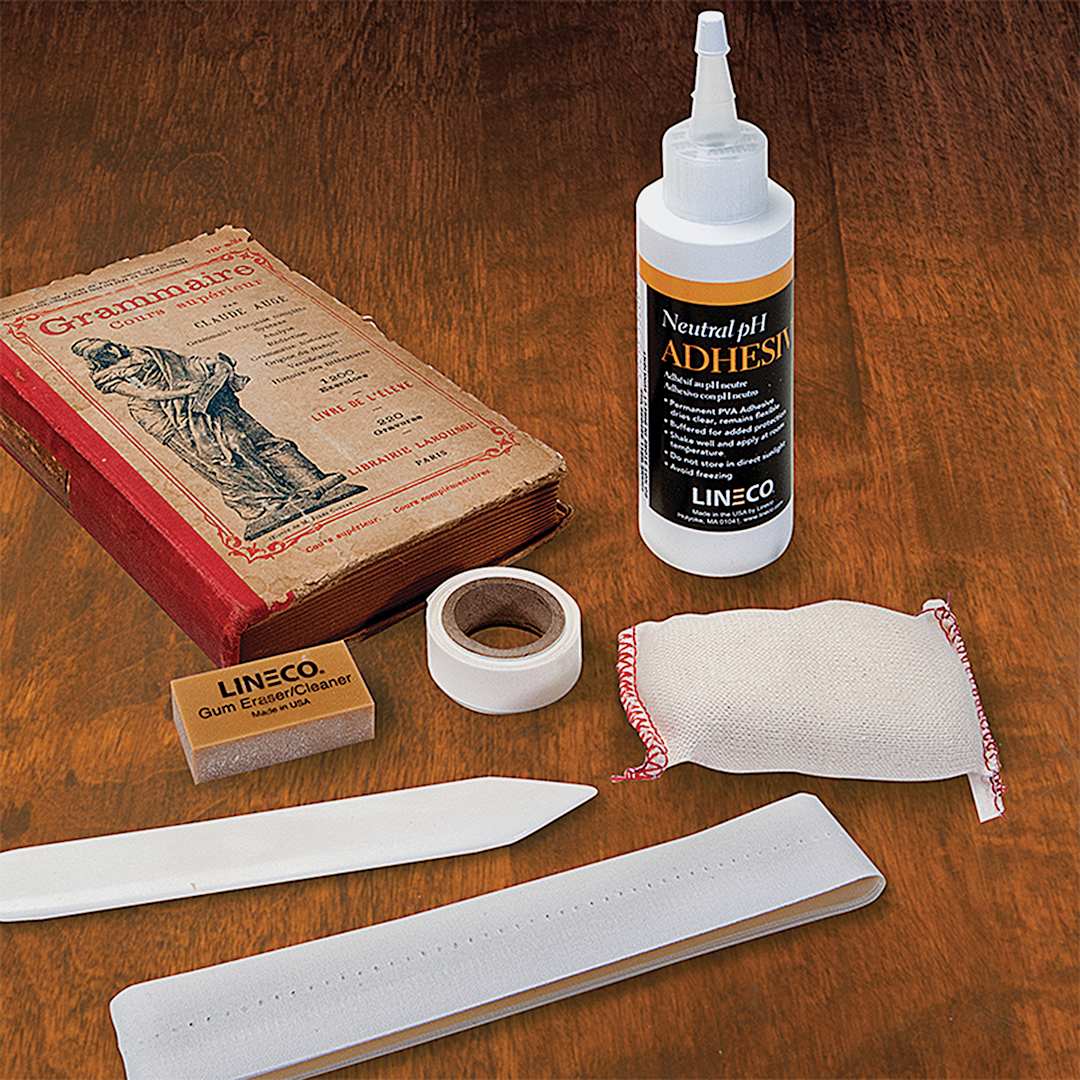 Open in modal - Lineco Book Repair Kit - Components of kit shown with book on table
