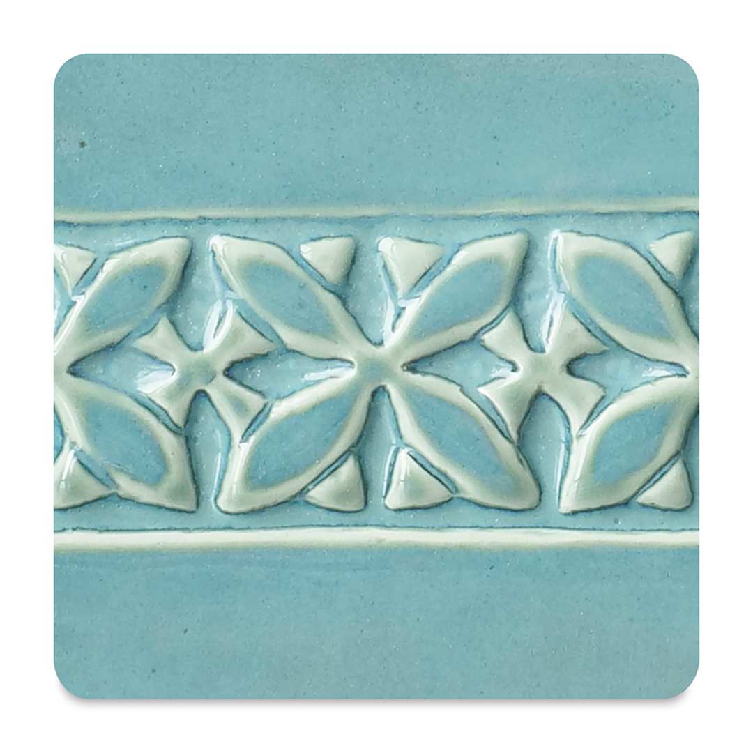 Open in modal - Amaco Potter's Choice Glaze - Gallon, Blue Lagoon. Color sample in blue with cream outlines.