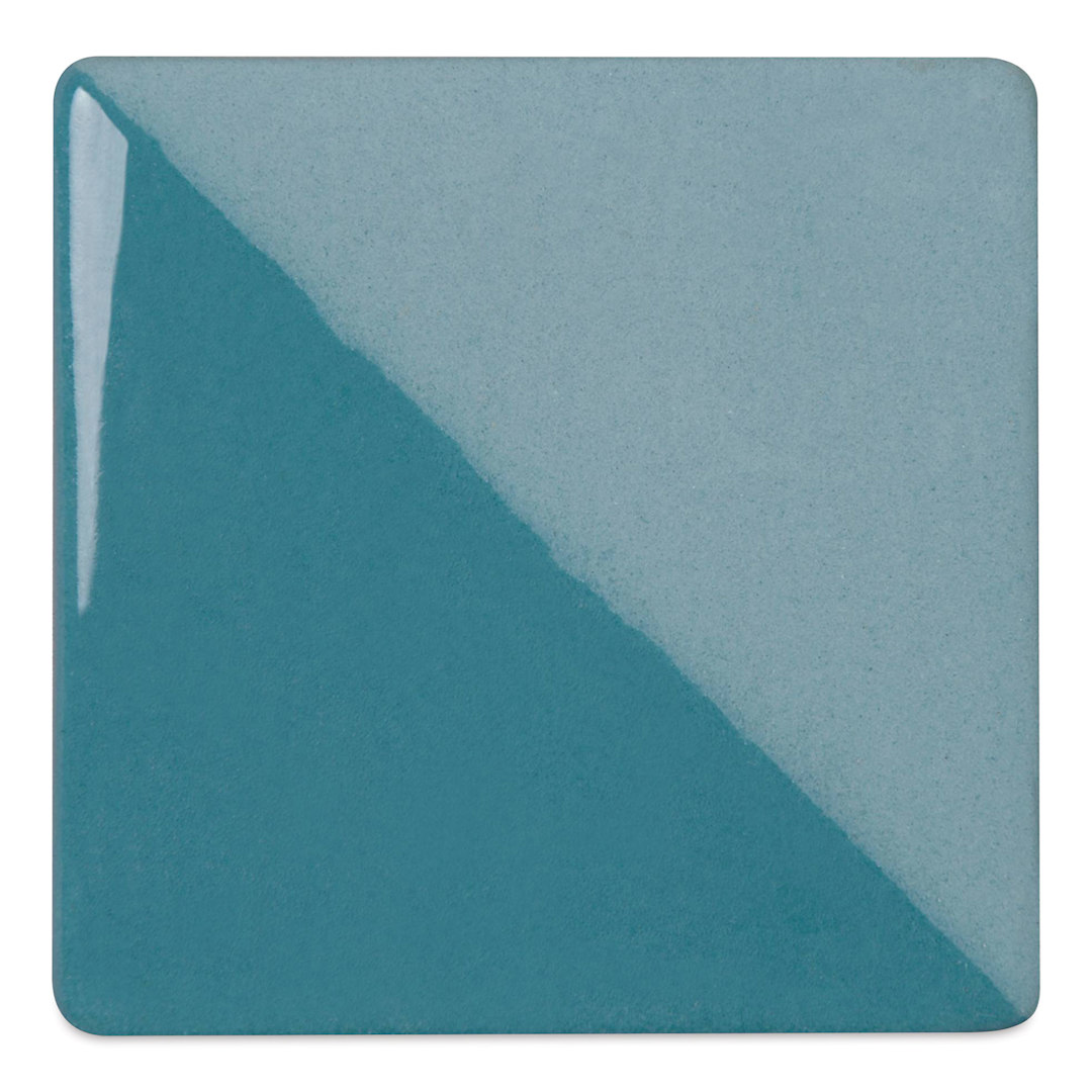 Open in modal - Speedball Ceramic Underglaze - Turquoise, Opaque, fired on white clay bisque tiles, half covered in Speedball Clear Glaze, fired to cone 05