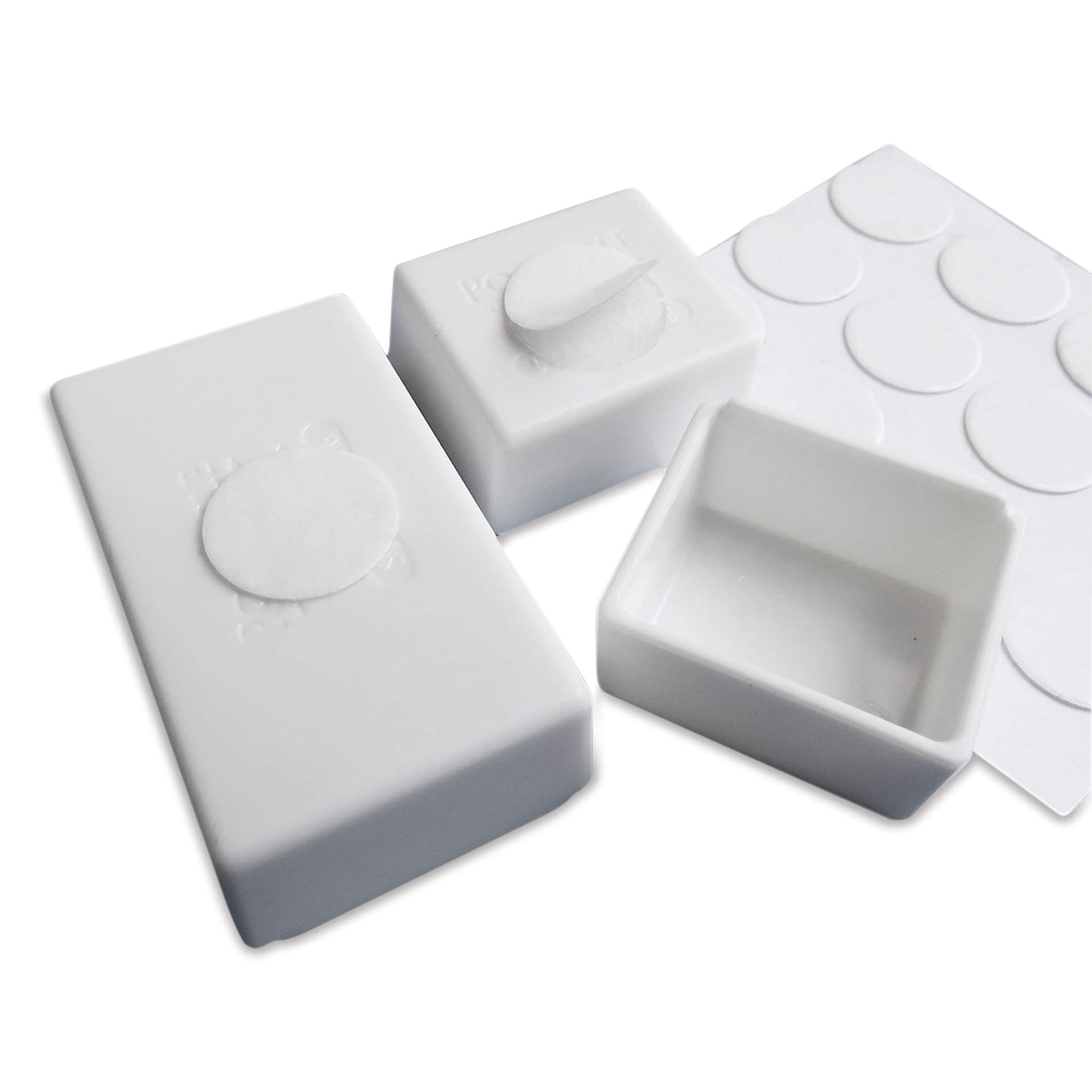Adhesive dots used to hold the pans in place