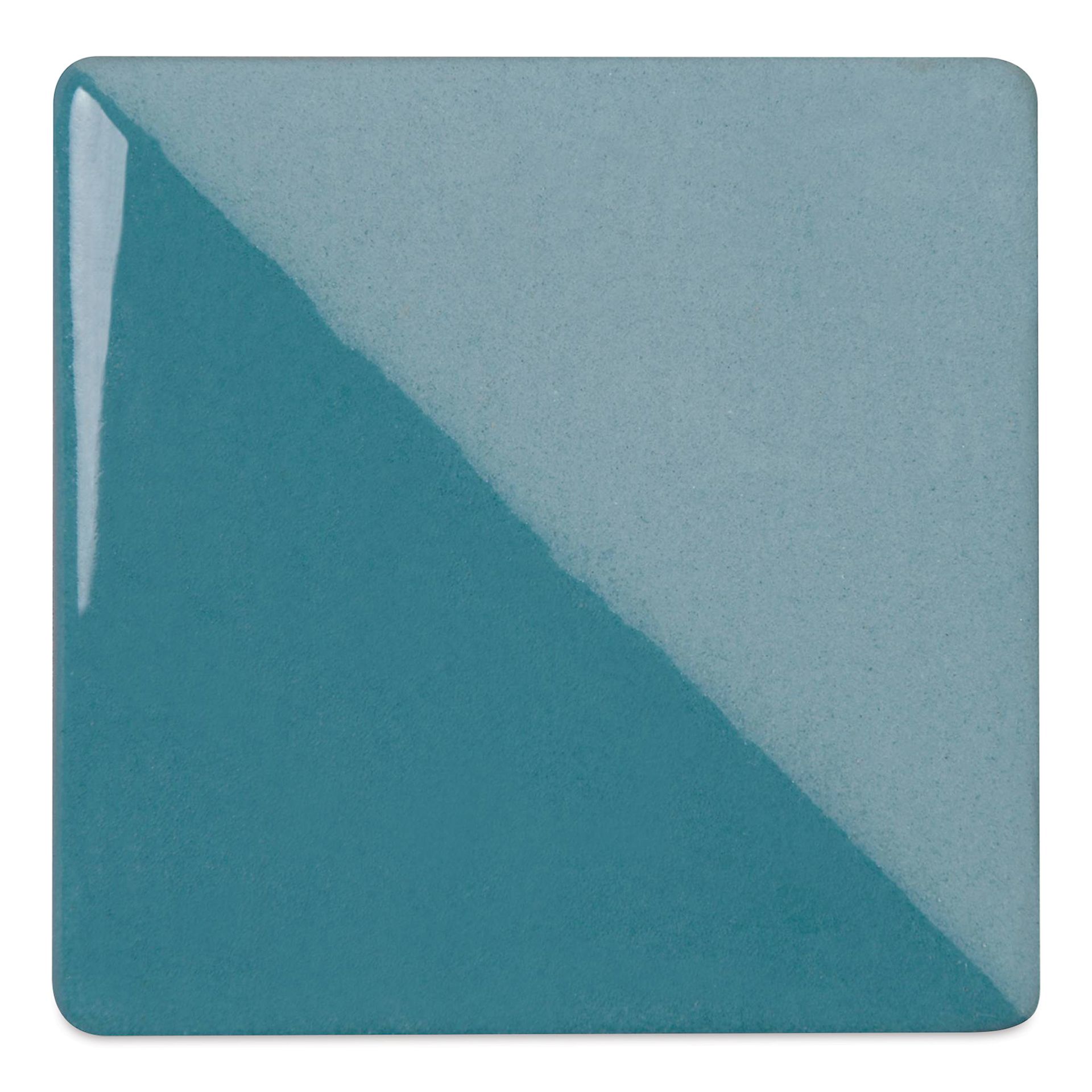 Speedball Ceramic Underglaze - Turquoise, Opaque, fired on white clay bisque tiles, half covered in Speedball Clear Glaze, fired to cone 05