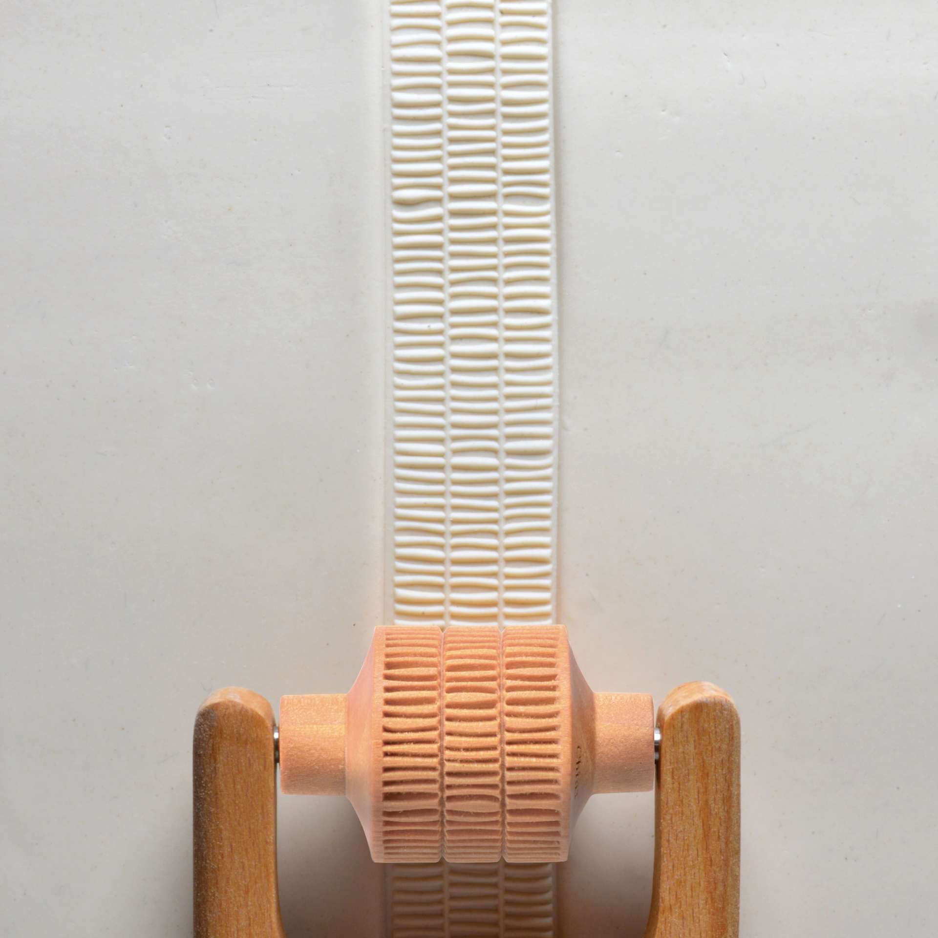MKM Pottery Tools Medium Handle Roller - Layered Lines applied to clay