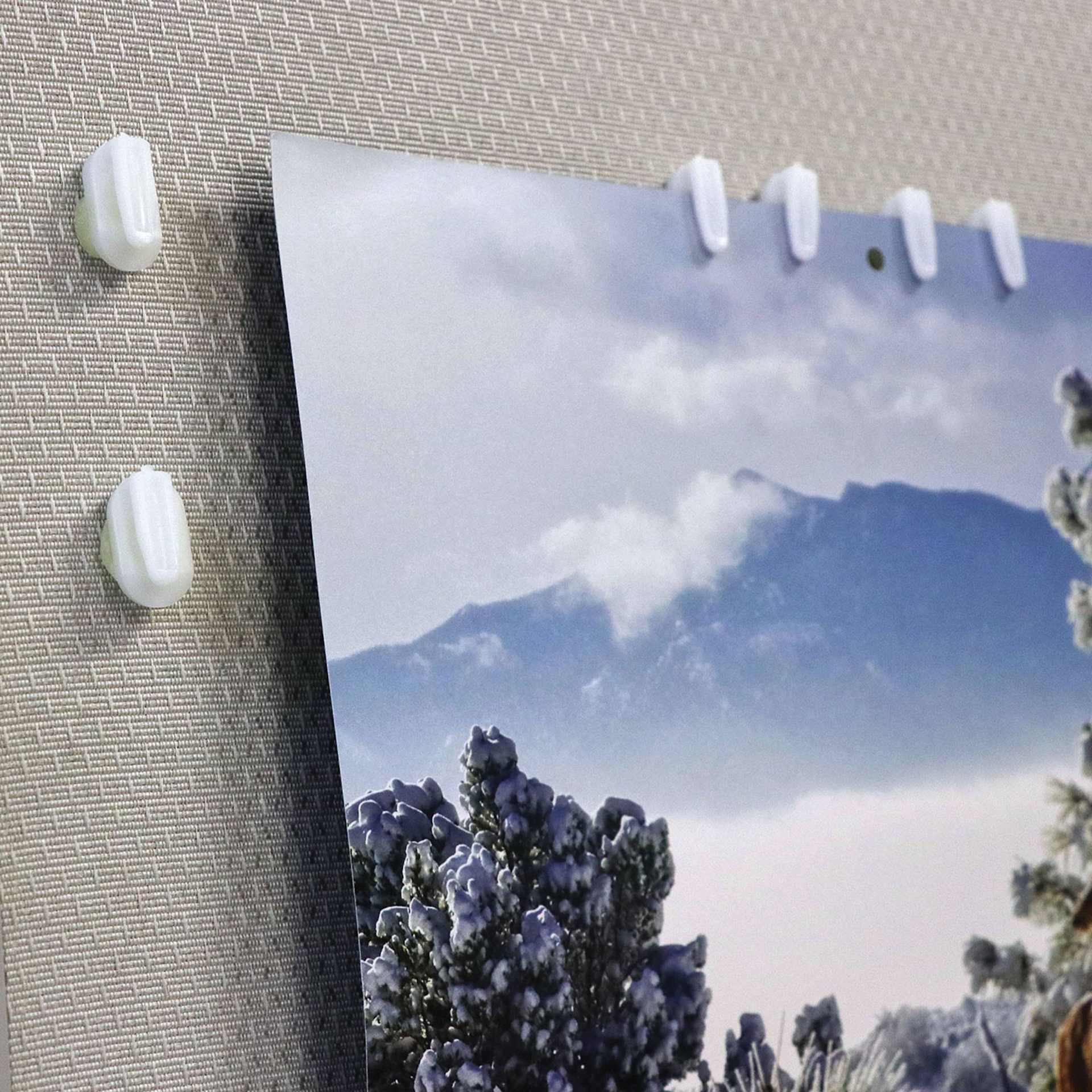 StikkiWorks StikkiClips - Adhesive Wax, Pkg of 20, clips being used to hold a poster. 