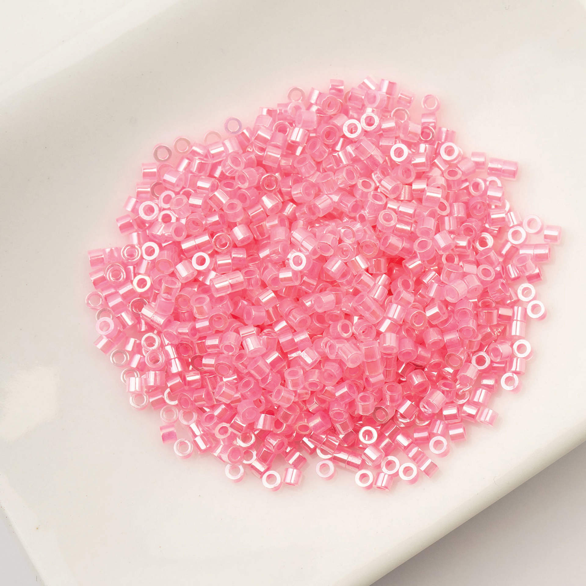 John Bead Cylin 11/0 Ceylon Cylindrical Seed Beads - Dark Crystal Pink Lined, 25g sitting in dish