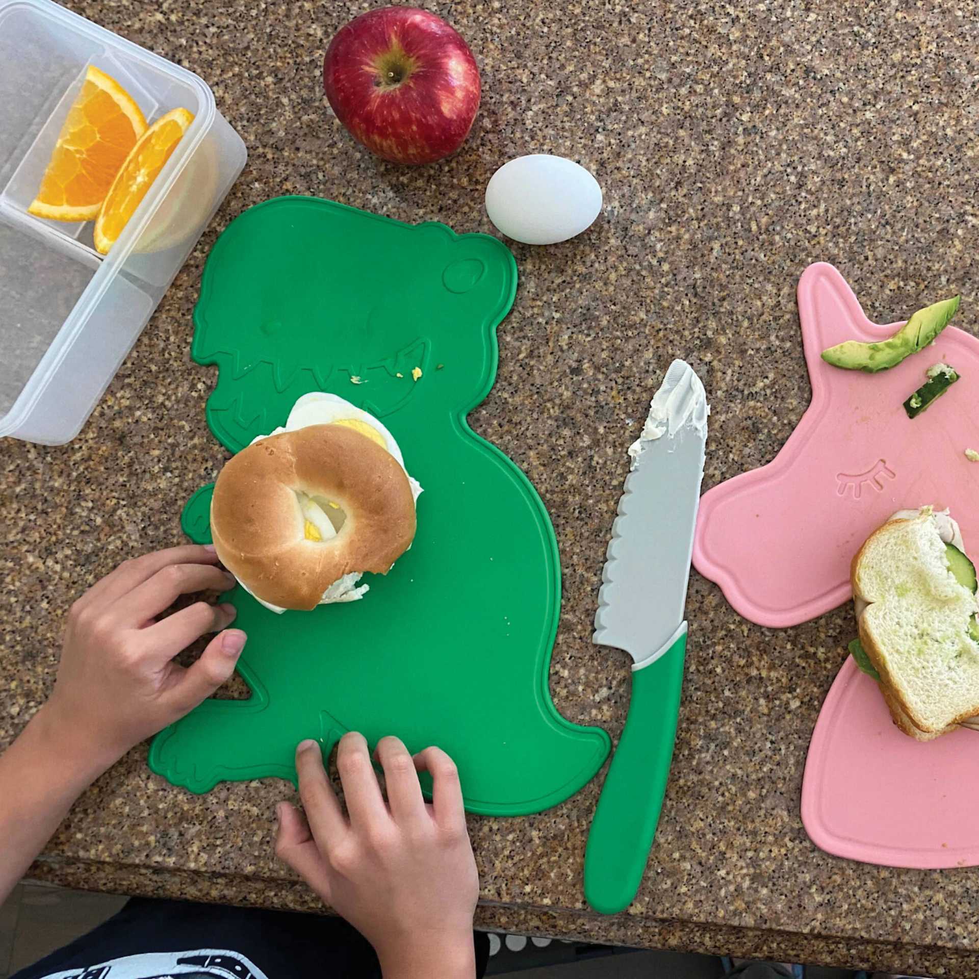 Handstand Kitchen Cutting Board & Knife Set, food on top of the Dinosaur cutting board.