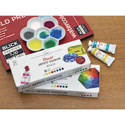Utrecht Artists' Gouache Paints and Sets - Mixing Set, Introductory Set, and Blick Premier Watercolor Pad on table
