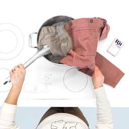 Rit Color Remover - Shirt shown partially dipped in pot of solution showing dye being removed